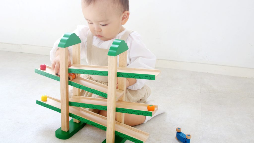 GENIの知育玩具・木のおもちゃ『森のうんどう会』を目で追う子ども:音と動きで集中力を育てる