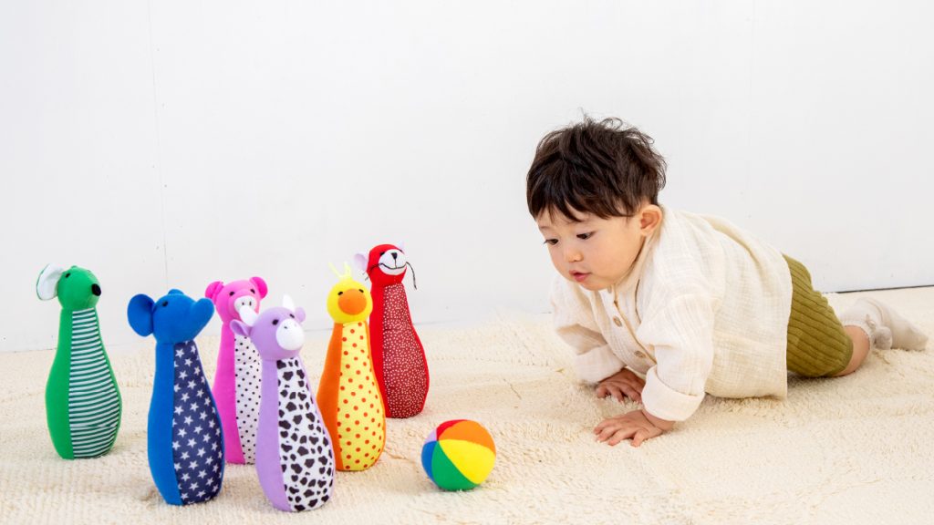 GENIの布製の知育玩具・布おもちゃ“ソフトボウリング”で遊ぶ男の子:視線を使った追視の発達サポート